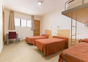 塞维利亚塞维利亚艾尔博古因图州文酒店的酒店客房带两张带橙色床单的床