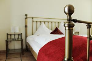 科隆阿卡兹恩鸿丰酒店的一张带白色床单和红色毯子的床