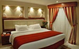 多哈荔湾套房酒店的一间卧室设有一张大床和一个窗户。