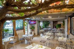 罗马欧瑞狄荣马酒店的树下设有桌椅的餐厅