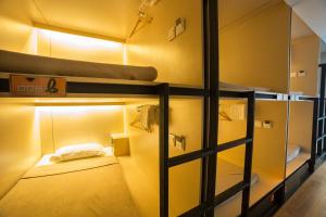 曼谷Cubic Bed Pratunam的客房设有两张双层床,配有灯