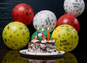 Meru梅鲁阿尔巴酒店的气球前带蜡烛的生日蛋糕