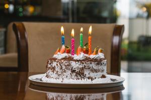 Meru梅鲁阿尔巴酒店的桌上的带蜡烛的生日蛋糕