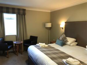 斯特灵罗伯特国王酒店的酒店客房,配有一张床和两把椅子