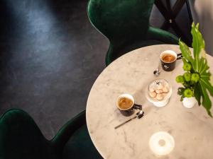 巴特瑙海姆Boutique Hotel K7的一张桌子,上面放着两杯咖啡和一盘食物