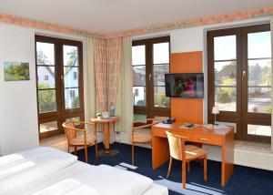 吕本瑙斯普里瓦尔德克酒店的酒店客房配有书桌和床。