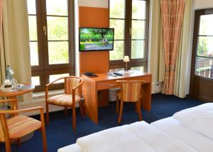 吕本瑙斯普里瓦尔德克酒店的酒店客房配有书桌和床。