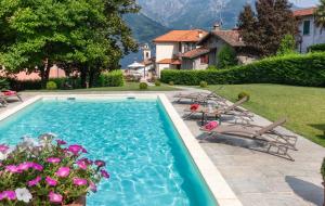 奥利维托拉里奥Villa La Dolce Vita的庭院内一个带椅子和鲜花的游泳池