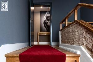 莱里亚Porta 20 Boutique Guesthouse的一条铺有红地毯的楼梯和一个楼梯箱