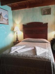 危地马拉安地瓜Posada San Sebastian的一间卧室配有一张床,上面有两条毛巾