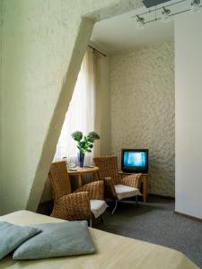 里加伊莉莎贝特设计酒店的配有桌椅和电视的客房