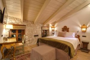约阿尼纳KAMARES Historic Boutique Hotel & Spa的一间卧室设有一张大床和石墙