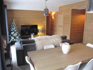 瓦卢瓦尔Le Bianca 102 Residence l'Epinette的客厅配有桌子和白色毛皮沙发