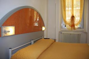 米兰阿德奇酒店的一间卧室配有一张带镜子的床和窗户