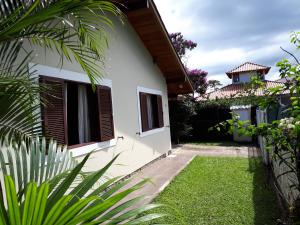 弗洛里亚诺波利斯Monsal Casa para Temporada的白色的房子,有绿草的院子