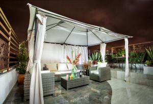 帕斯托Hotel San Blass Boutique的庭院设有白色的天篷、椅子和桌子。