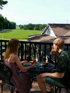 ShippenvilleThe Inn at Deer Creek Winery的坐在阳台上桌子上的男人和女人