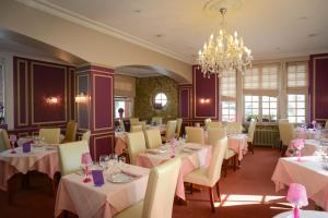 卡朗唐奥贝奇诺曼德酒店的一间带桌椅和吊灯的用餐室
