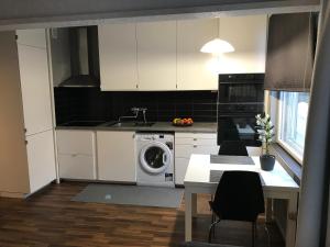 图尔库Apartment in Turku center的厨房配有白色橱柜和洗衣机。