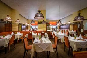 维也纳格拉本酒店的餐厅配有白色的桌椅和灯光