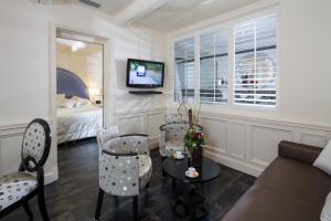 莱蓬特奥贝奇温泉酒店的客厅配有沙发、椅子和电视