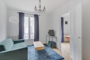 巴黎Lovely Parisian Flat - Louvre rue St Honoré的客厅配有蓝色的沙发和桌子