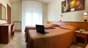 圣乔瓦尼·罗通多Hotel Sollievo - San Gennaro的酒店客房设有两张床,上面有一台笔记本电脑