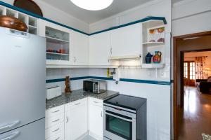 辛特拉Sintra 23的厨房配有白色橱柜和炉灶烤箱。