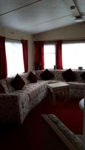 Winthorpe6 berth on Northshore En-suite Sunnyside的带沙发和红色窗帘的客厅