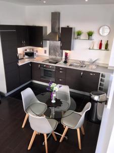 法恩伯勒Blue Sky Apartments @Wallis Square, Farnborough的厨房配有桌椅和水槽。
