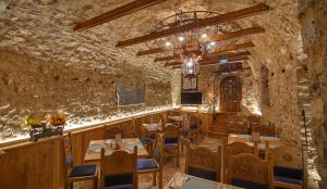 约阿尼纳KAMARES Historic Boutique Hotel & Spa的餐厅设有石墙和桌椅