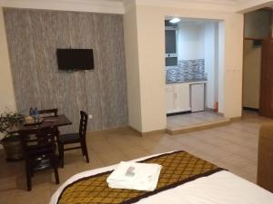 麦可乐Mekelle Hotel的酒店客房设有一张床铺、一张桌子和一间厨房。