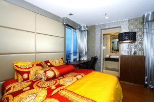 北芭堤雅Lux SL Luxury Style of Life 5的一间卧室配有一张黄色和红色毯子的床