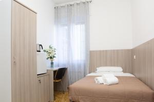 热那亚Affittacamere San Martino的一间卧室配有一张床、一张书桌和一个窗户。