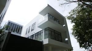 Kampong Batang MelekekThe Dahlias at Afamosa Melaka的一座大型白色建筑,设有玻璃窗