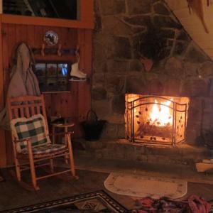 加特林堡Buckberry Creek Chalet的石制壁炉,带摇椅的房间