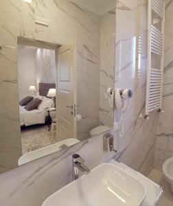 卢切拉FLOS Guest House的白色的浴室设有水槽和镜子