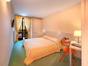 佛加里达阿拉斯加酒店的卧室配有1张床、1张书桌和1张桌子及椅子