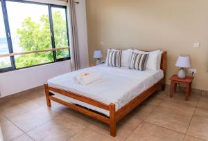 马埃岛Villa Lima的一间卧室设有一张大床和两个窗户。