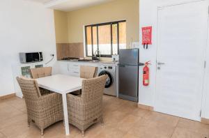 马埃岛Villa Lima的厨房配有桌椅和冰箱。