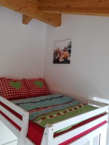 PillFerienhaus Hubertus für 8 Personen的一间卧室配有一张红色和绿色的棉被的床