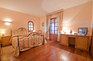 格罗塔费拉塔泰努塔谷斯马诺酒店的一间卧室配有一张床和一台电视,铺有木地板