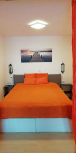 穆赫克雷斯的艾根Appartmenthaus Kern的一间卧室配有一张带橙色床罩的床