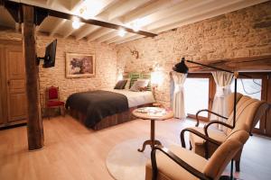 圣塞西尔Les Chambres du Chat的一间卧室设有一张床和砖墙