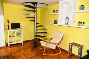 丘利利亚Casa Rural El Castillo的客厅设有螺旋楼梯和椅子