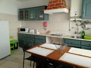 拉戈斯拉各斯市中心旅馆的厨房配有绿色橱柜和桌椅