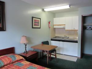 鲁珀特王子港阿里达汽车旅馆的配有床和桌子的房间以及厨房