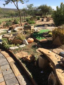 VoigtlandWindhoek Rural Self Catering的花园,花园内设有池塘、南瓜和长凳