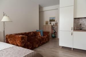 维尔纽斯M.K. Apartments的客厅配有棕色沙发和白色橱柜