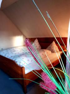 埃姆登Hotel & Restaurant Gulfhof的一间卧室配有一张带粉色床单的木床
